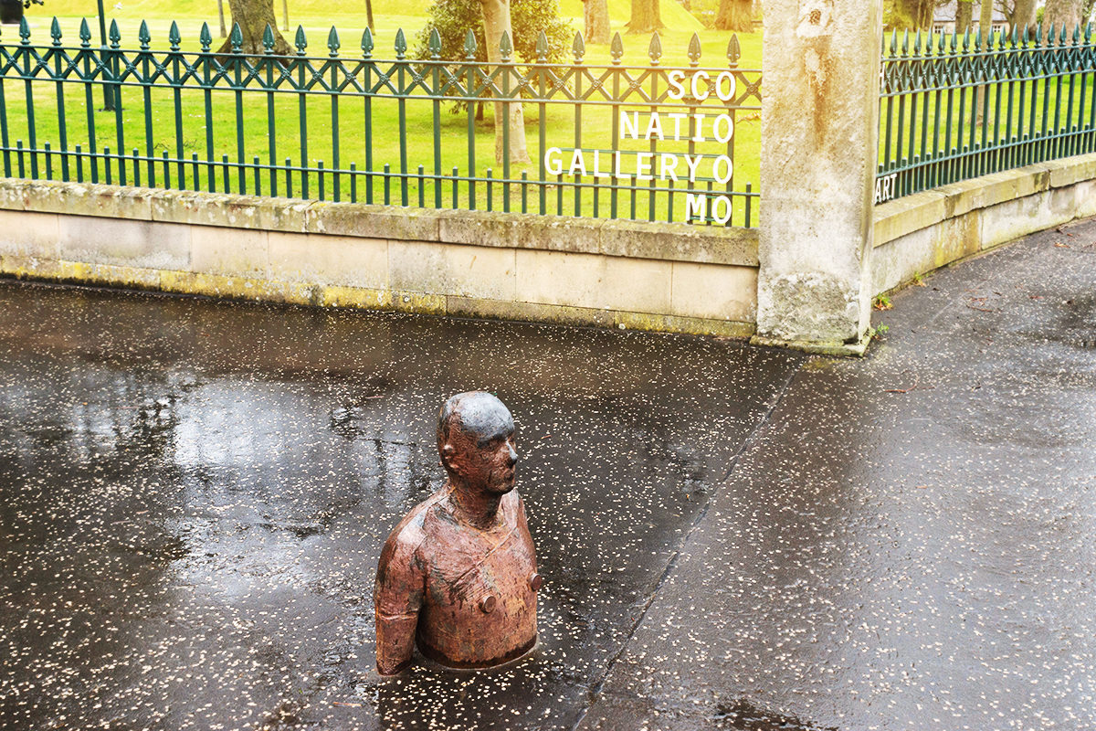 Скульптура человека в земле перед зданием галереи, Эдинбург
